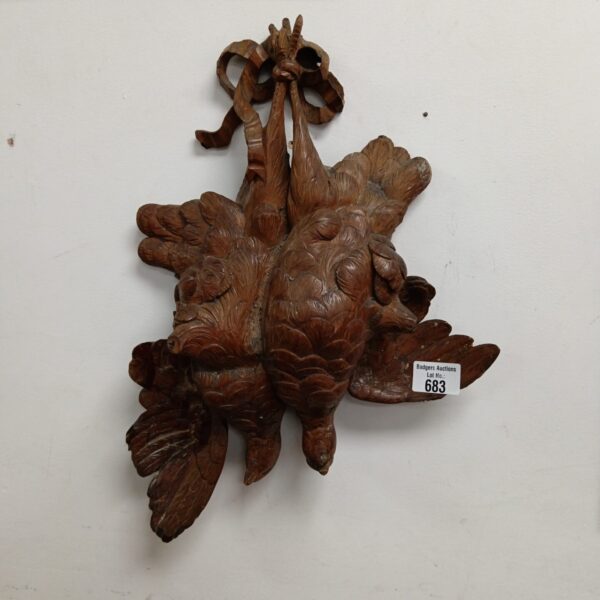 Pair of vintage Black Forest carved wooden pheasants on display.