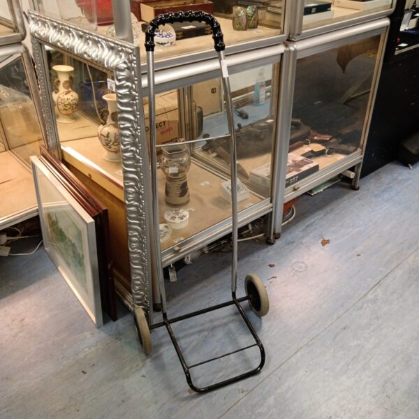 Vintage metal shopping bag trolley with black frame and wheels.