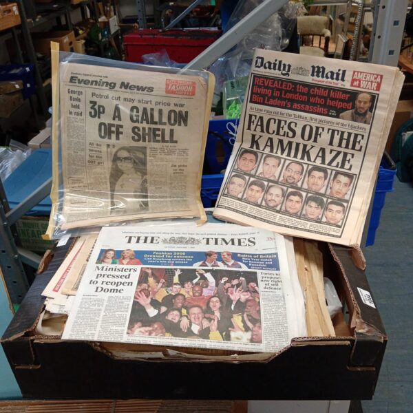 Vintage British newspapers in a lot, capturing historic events.