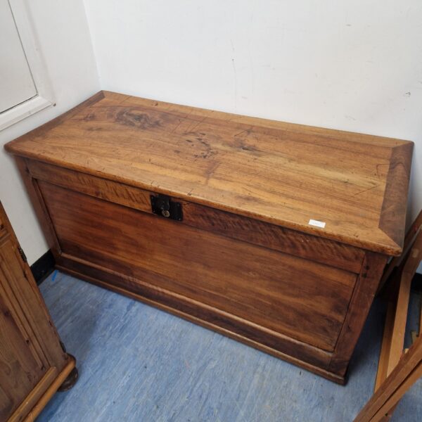 Front view of a vintage wooden blanket chest.