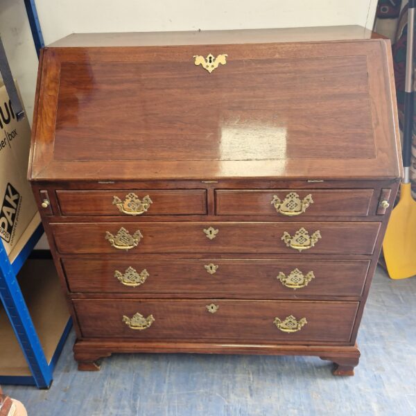 Vintage mahogany writing bureau with drawers, front view.