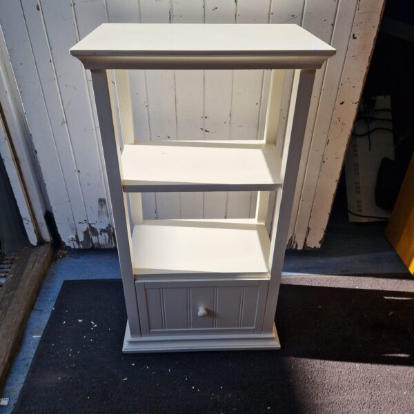 White wooden side cabinet with drawer and shelves for display.