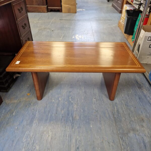 Small teak coffee table with inlaid wood design.