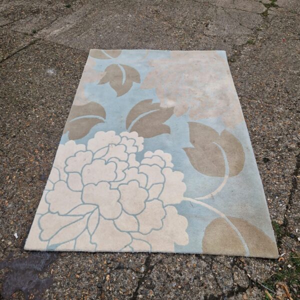 Blue floral rug with a repeating pattern, ideal for home decor.