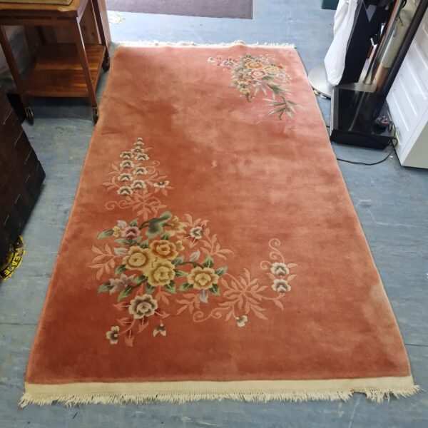 Vintage pink floral wool rug with a classic 20th-century design.