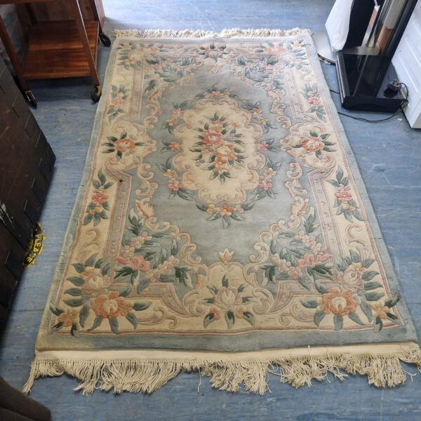 Vintage blue floral wool rug with a patterned design.