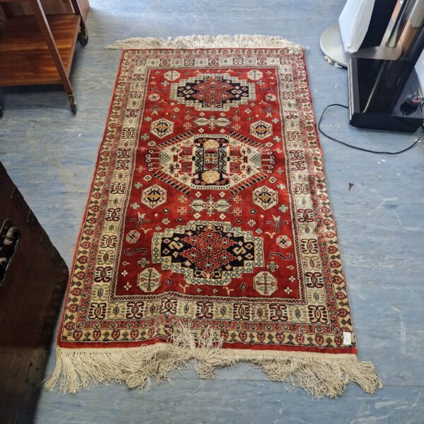 Vibrant red Indian style rug with geometric patterns.
