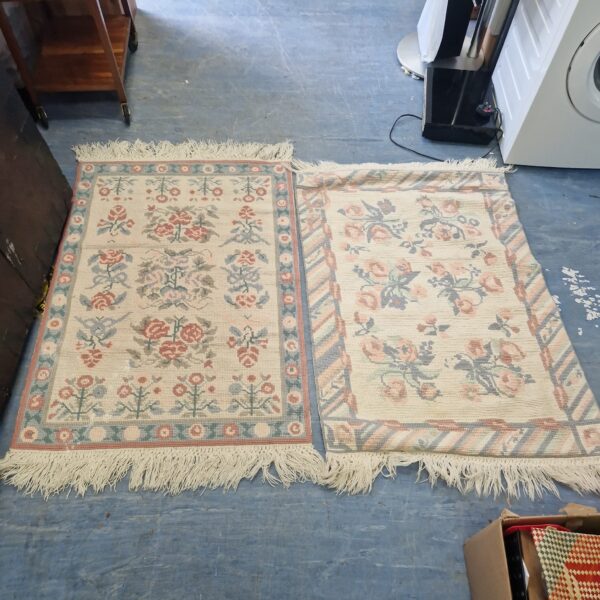 Cream floral patterned rugs with fringed edges, vintage style.