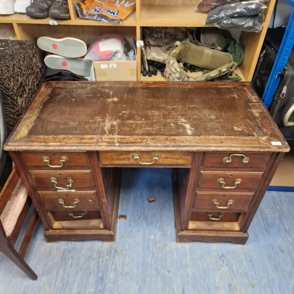 Vintage writing desk with leather top, ideal for restoration project.