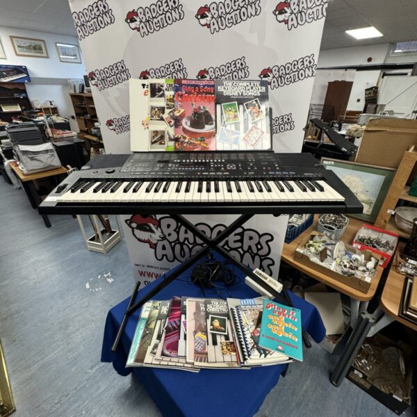 Yamaha PSR-410 keyboard with sheet music and stand.
