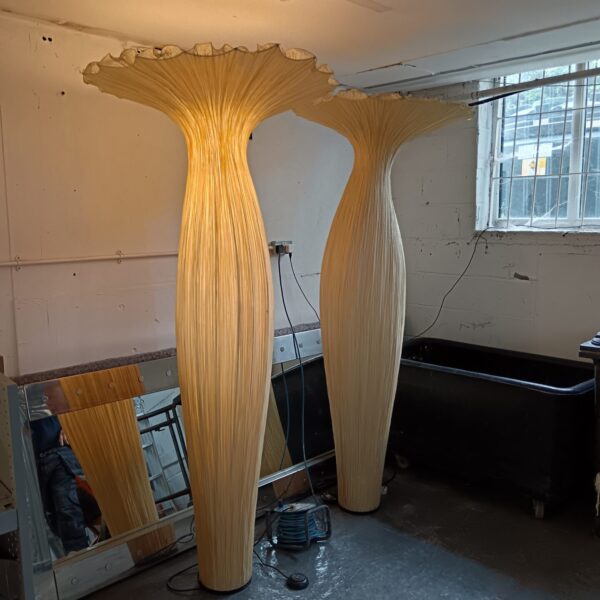 Pair of tall designer floor lamps in a hotel setting.