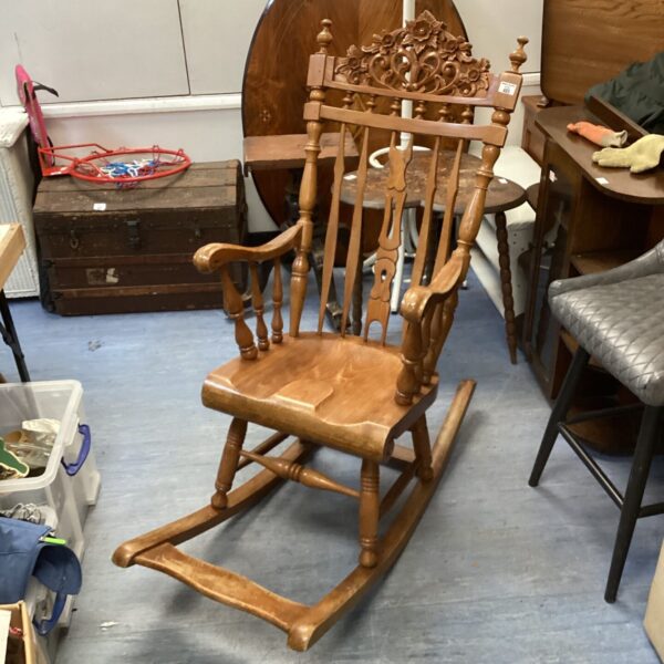 Detailed antique carved rocking chair with ornate back.