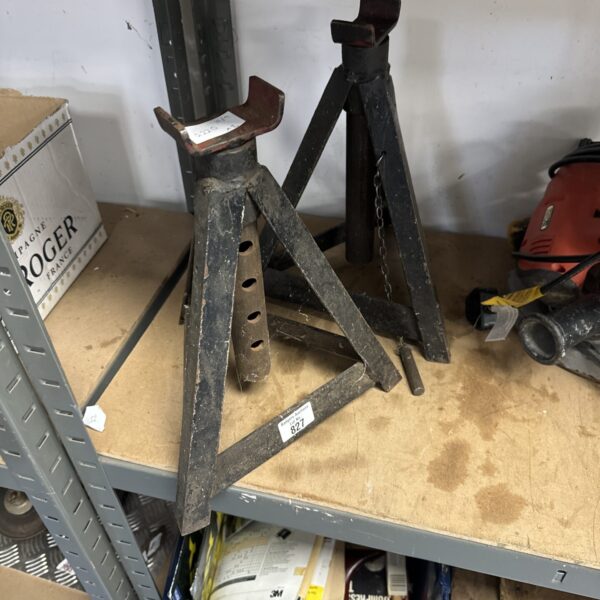 Pair of used axle stands in a workshop setting.