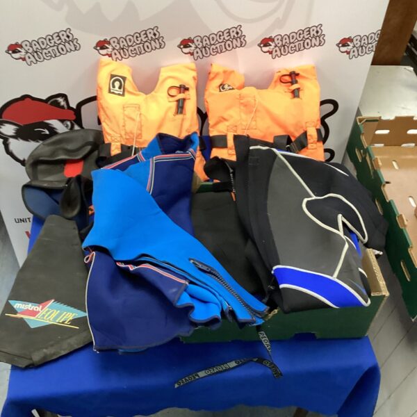 Children's life jackets and colourful bodysuits in a lot.