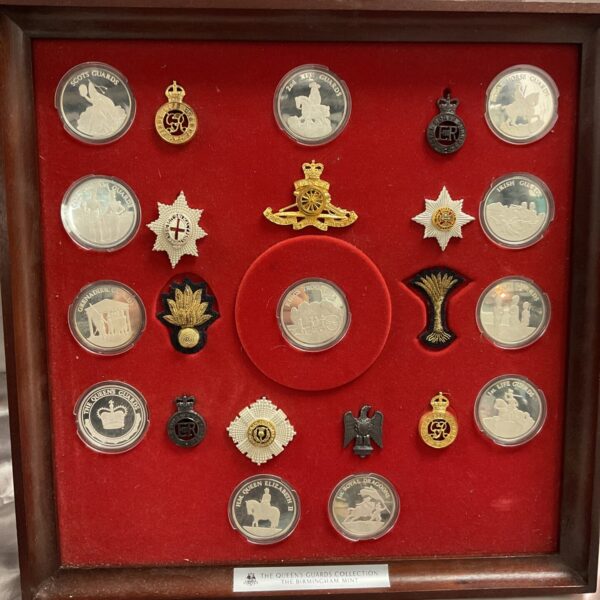 Queen's Guard Collection featuring cap badges and hallmarked silver coins.