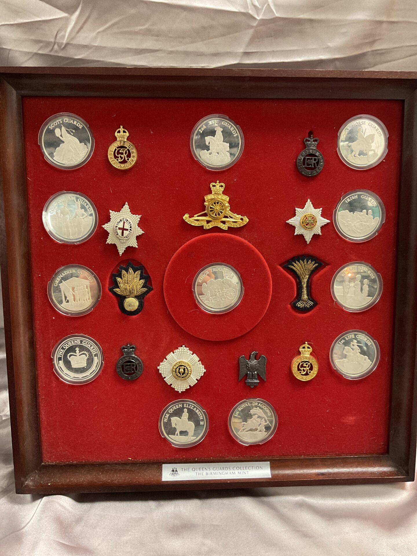 928 The Birmingham Mint The Queens Guard’s Collection Cap Badges and Twelve 45g Hallmarked Silver Coins