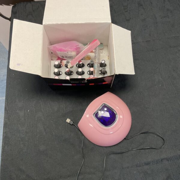 UV nail lamp with gel polish bottles for manicures.