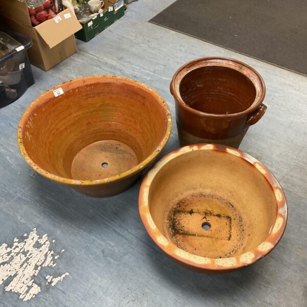 Three large terracotta planters for garden use.