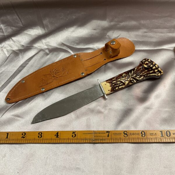 Vintage stag horn knife with leather sheath, classic hunting style.