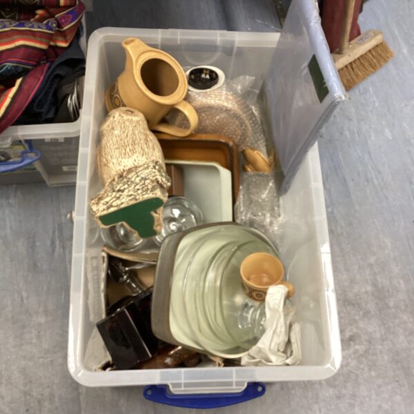 Mixed kitchen items in a plastic storage box, vintage style.