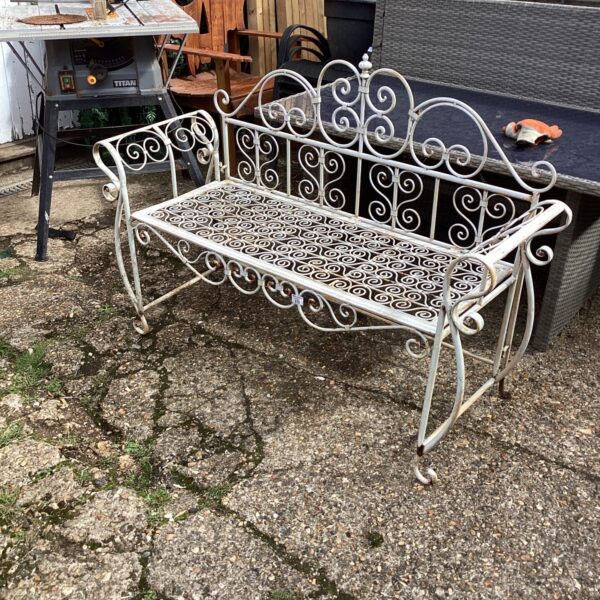 Ornate vintage metal garden folding seat with scrolling details.