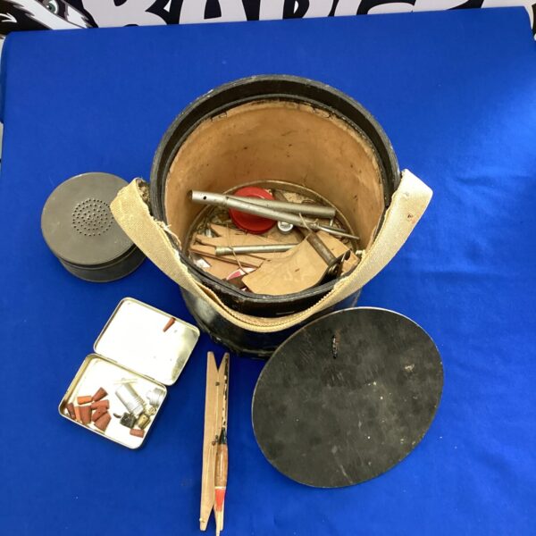 Vintage fishing tackle box with antique angling equipment inside.