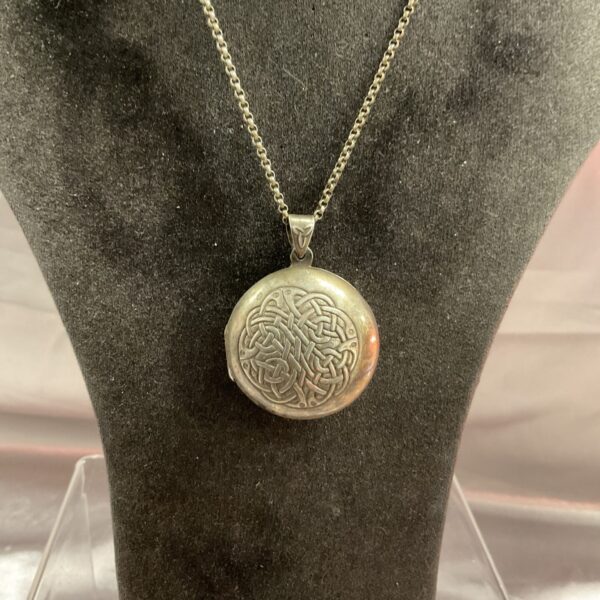 Silver Celtic locket necklace with intricate knotwork design.