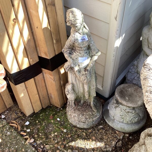 Weathered lady garden statue in a garden setting.