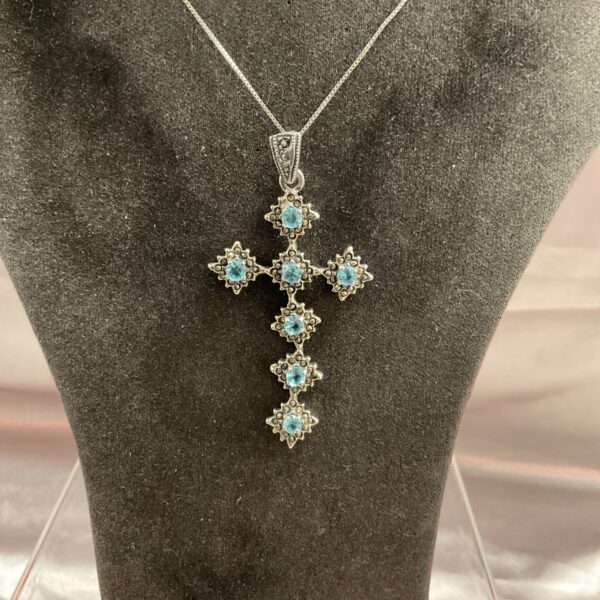 Elegant 925 silver cross pendant with blue topaz stones on a chain.