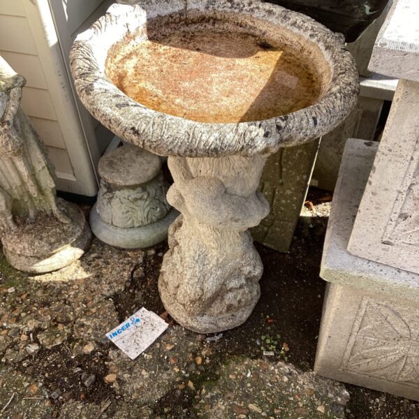 Classic stone bird bath in a garden setting.