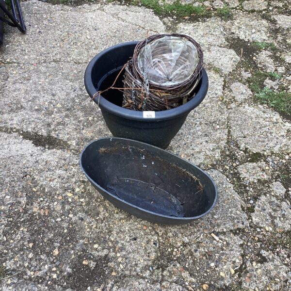 Black plastic garden planter for outdoor plants and hanging displays.