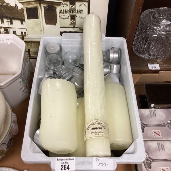 Assorted tea lights and candles in a plastic container.