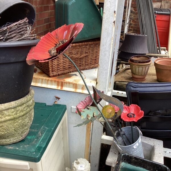Vibrant metal garden flowers in a rustic galvanised holder.