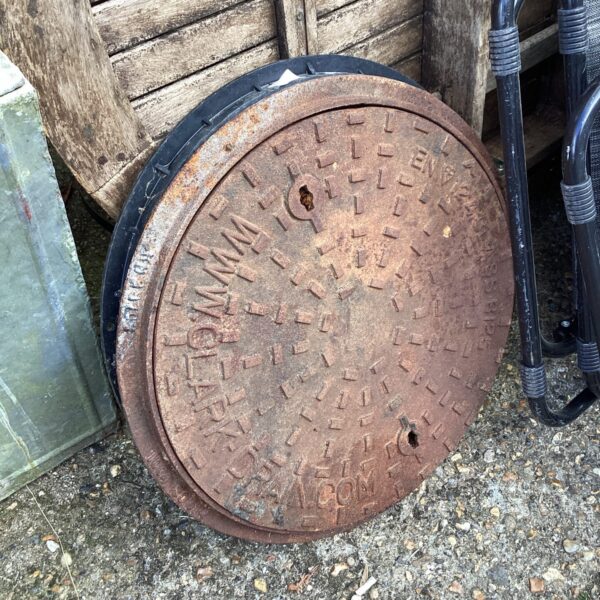 Weathered cast iron manhole cover for industrial decor.