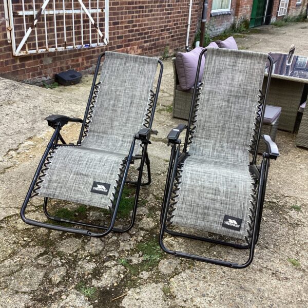 Two Traspass reclining garden chairs in a garden setting.