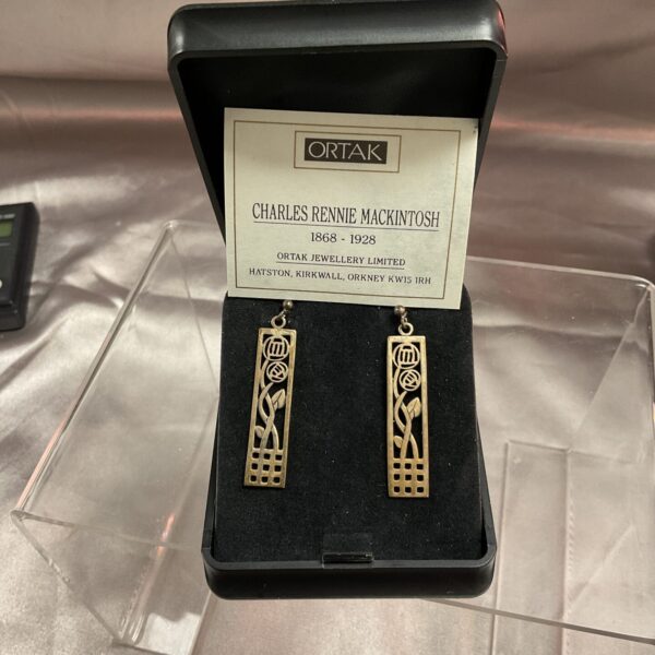 Silver Ortak Charles Rennie Mckintosh Art Nouveau earrings on display.