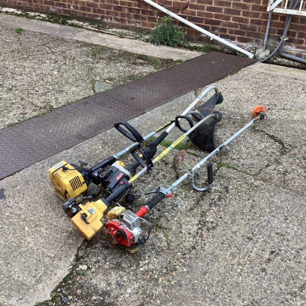 Lot of four petrol strimmers for garden maintenance and landscaping.