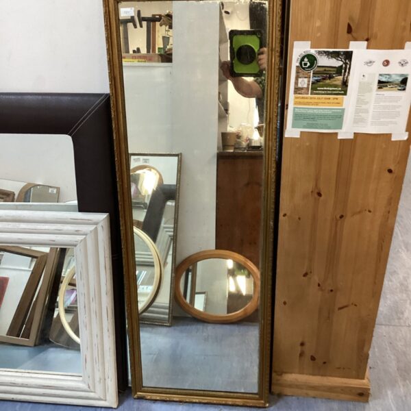 Large gilt framed mirror with a decorative frame.
