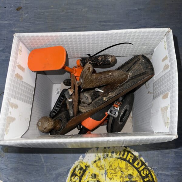 Vintage hand tools in a lot, showing signs of age and wear.