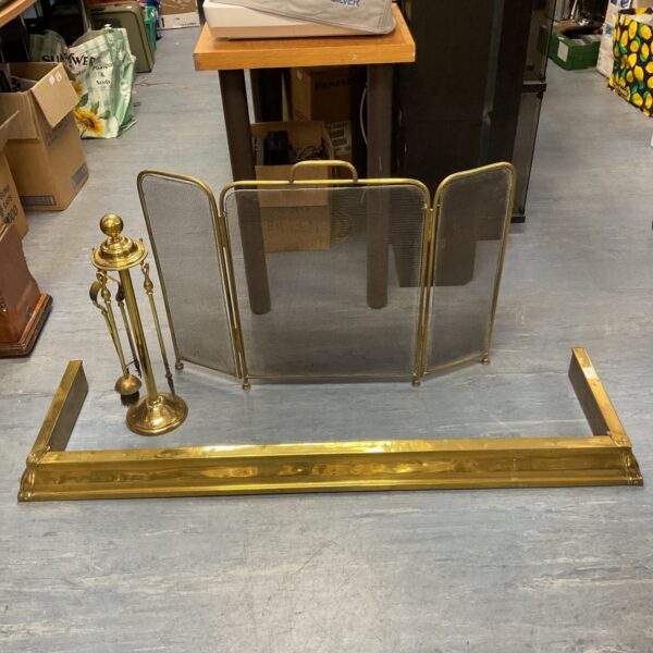 Antique brass fireplace fender with firescreen and companion set.