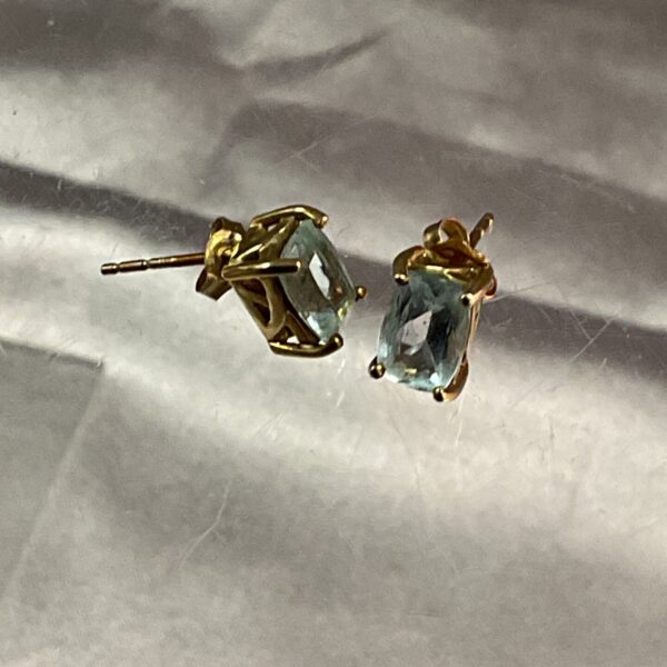 Hallmarked 9ct gold stud earrings with blue topaz gemstones.