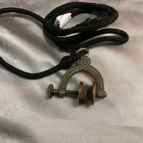 Antique Victorian skirt lifter with black cord.
