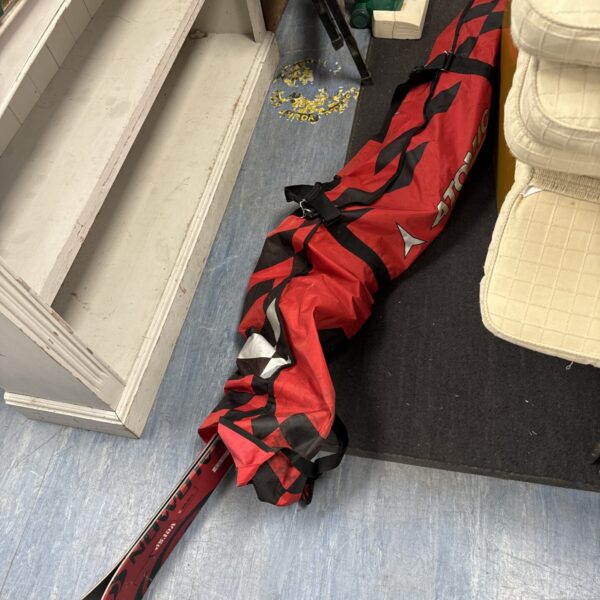 Red and black ski bag with Salomon Verse 5 skis partially visible.