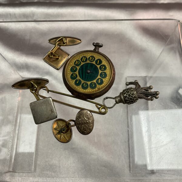 Antique pocket watch parts lot with decorative fob and movement.