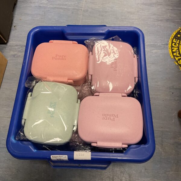 A box of colourful plastic kids lunchboxes for school.