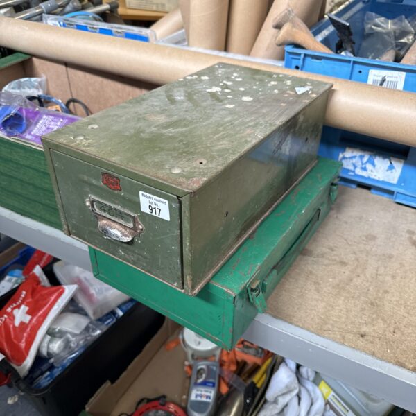 Two green vintage metal storage boxes with wear.