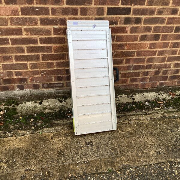 Silver aluminium mobility ramp for wheelchair access.