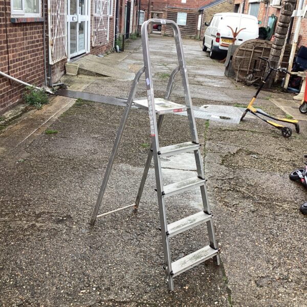 Aluminium step ladder in a garden setting, useful for DIY tasks.