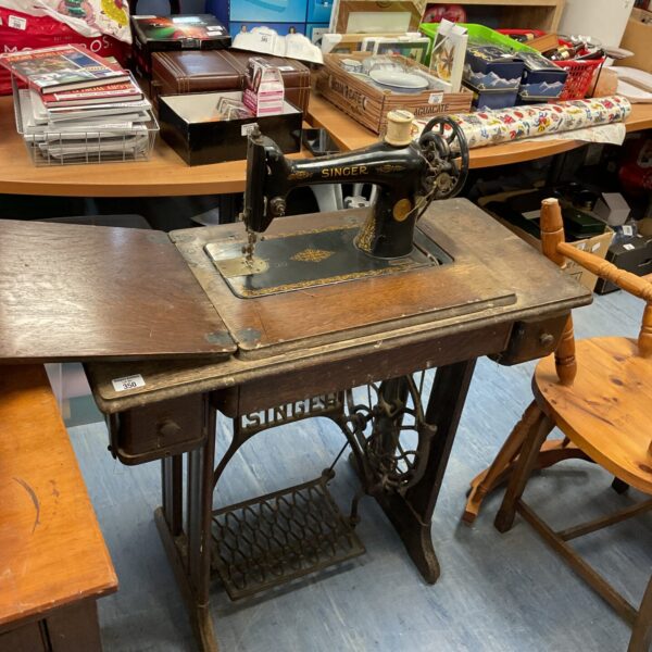 Antique Singer treadle sewing machine in original table.