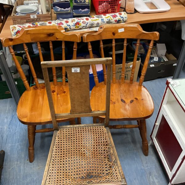 Lot of three vintage pine country kitchen chairs with rustic charm.